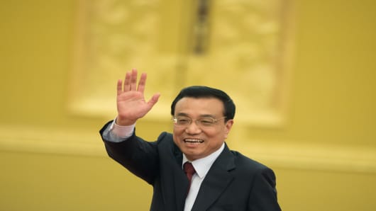 New Chinese Premier Li Keqiang waves as he leaves his first press conference after the closing session of the National People's Congress  at the Great Hall of the People in Beijing on March 17, 2013